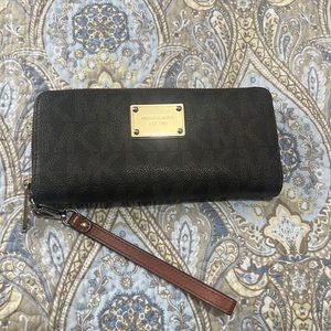 Used Michael Kors Wallet. Used condition has wear and scratches on metal plate.